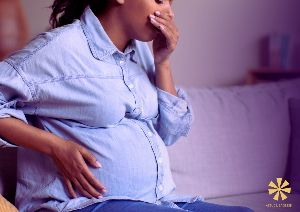 Une femme enceinte met la main devant sa bouche car elle a des nausées.